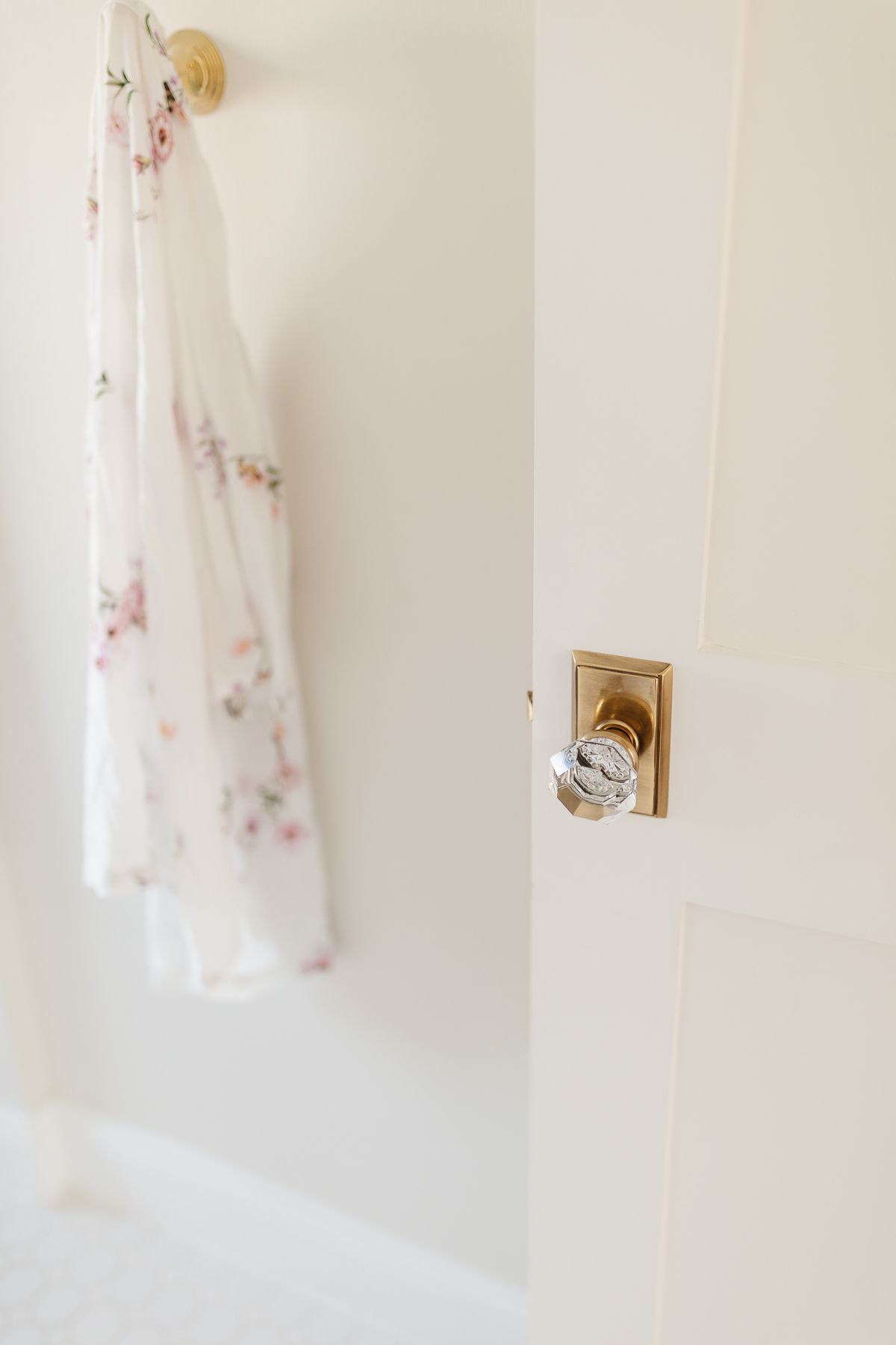 A glass door knob on a white door opening into a bathroom