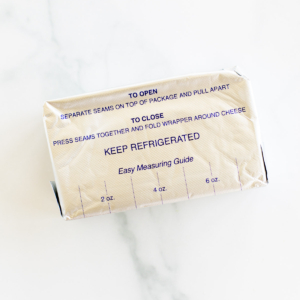 A block of cream cheese in its packaging with an easy measuring guide printed on the wrapper, highlighting whether you can freeze it for extended freshness.