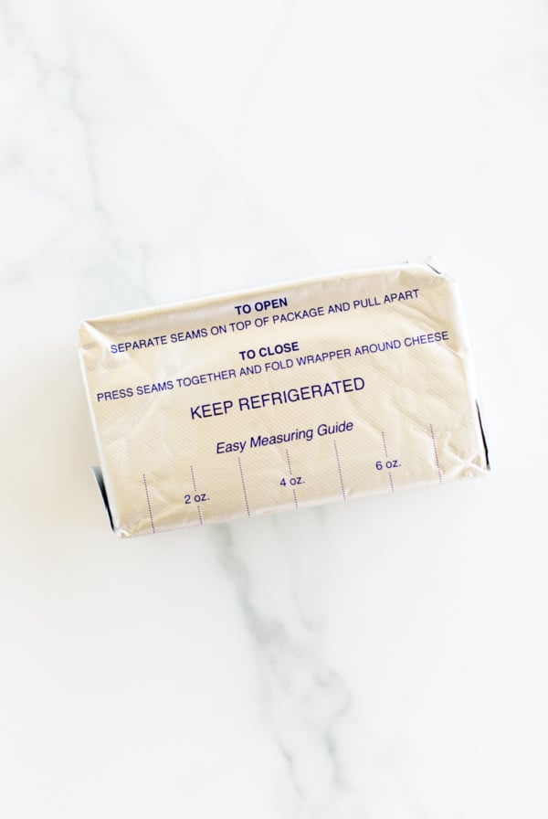 A block of cream cheese in its packaging with an easy measuring guide printed on the wrapper, highlighting whether you can freeze it for extended freshness.