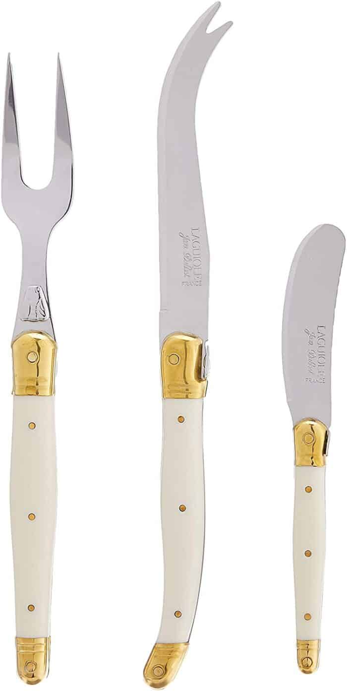 Set of three ivory and gold cheese knives on a white background