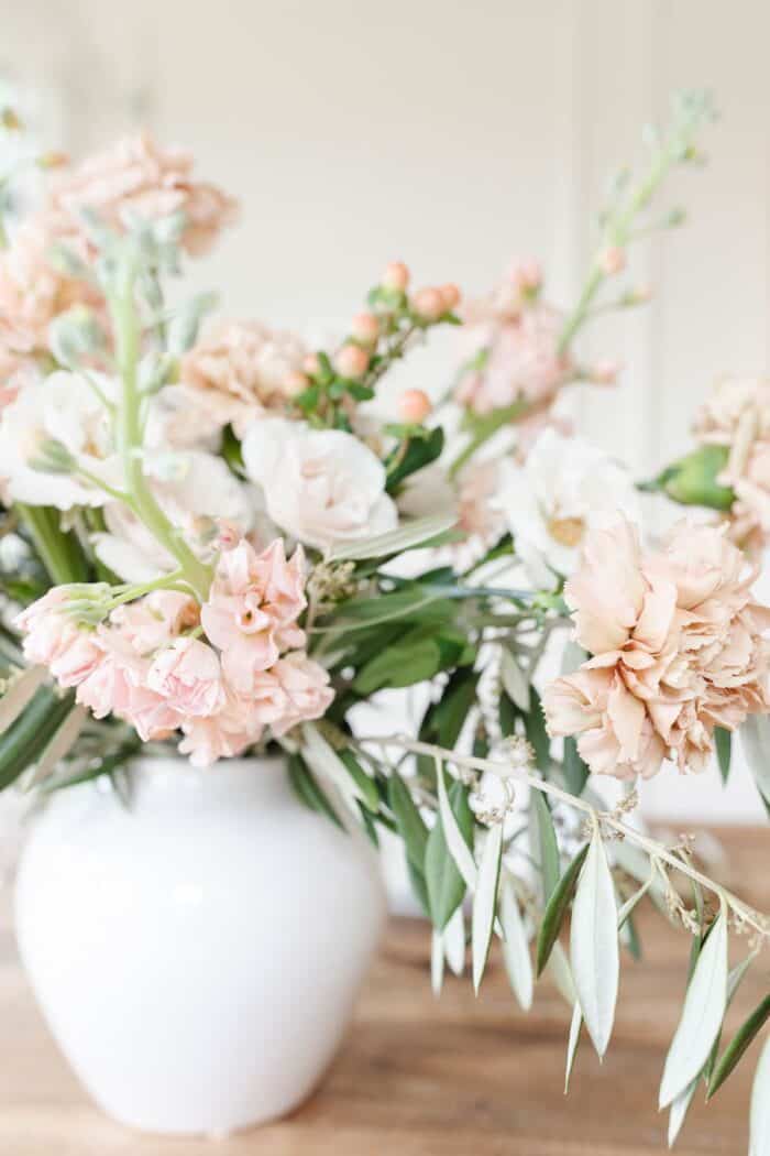 dianthus caryophyllus in a vase arrangement of antique and cream colors.