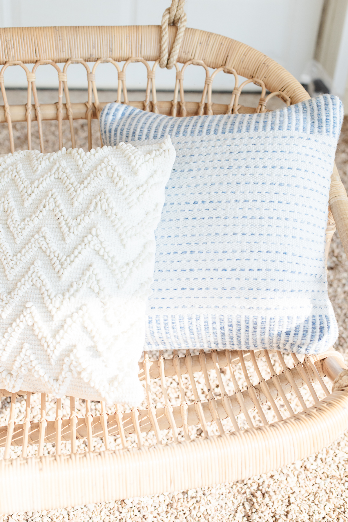 Blue and white pillows on a rattan sofa.
