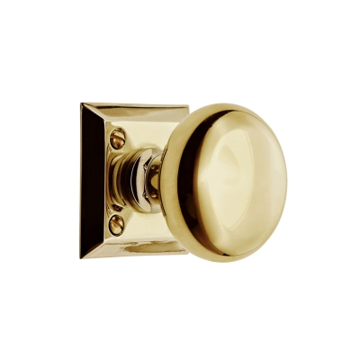 an unlacquered brass door knob on a white background.