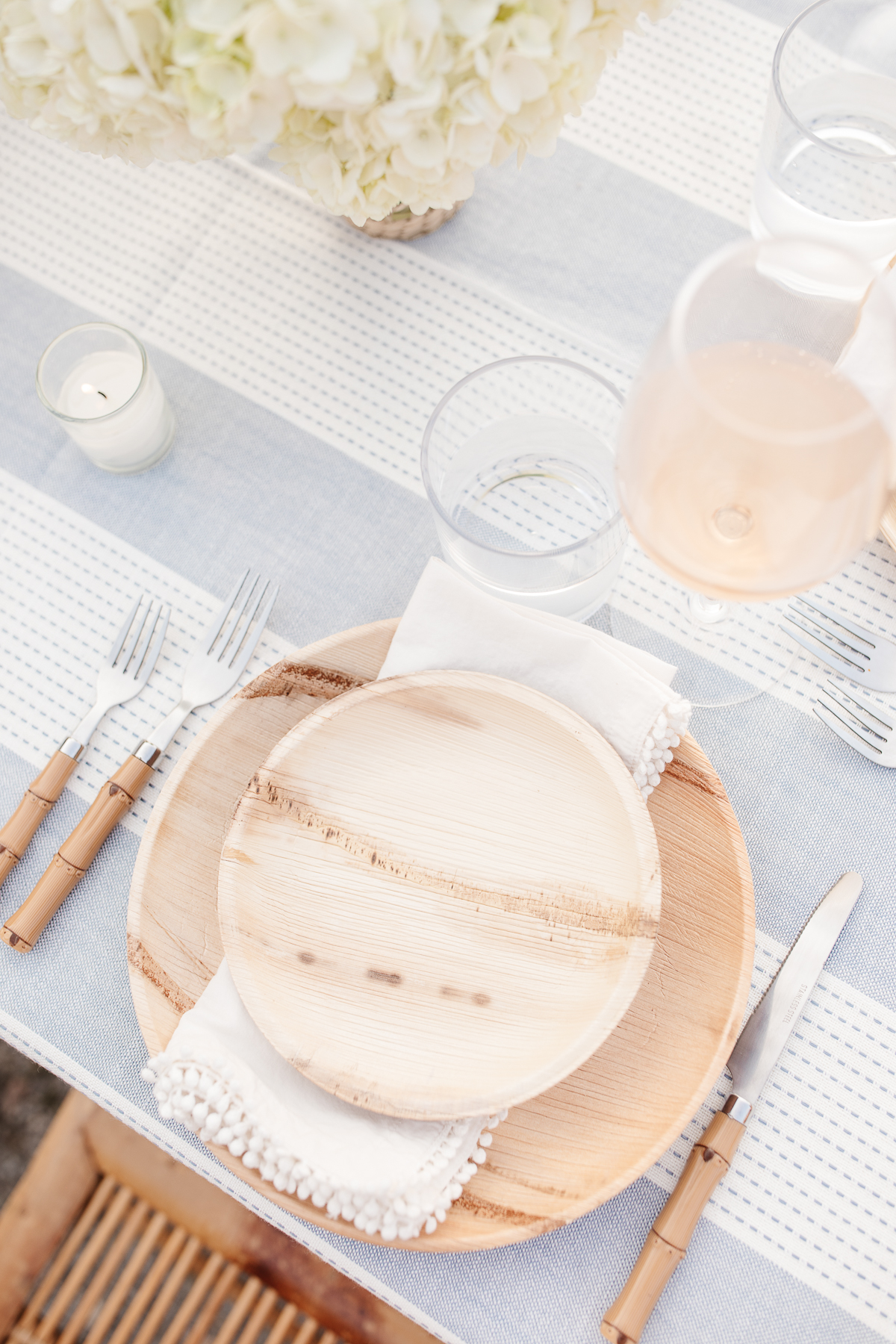 A blue and white table cloth set with bamboo plates