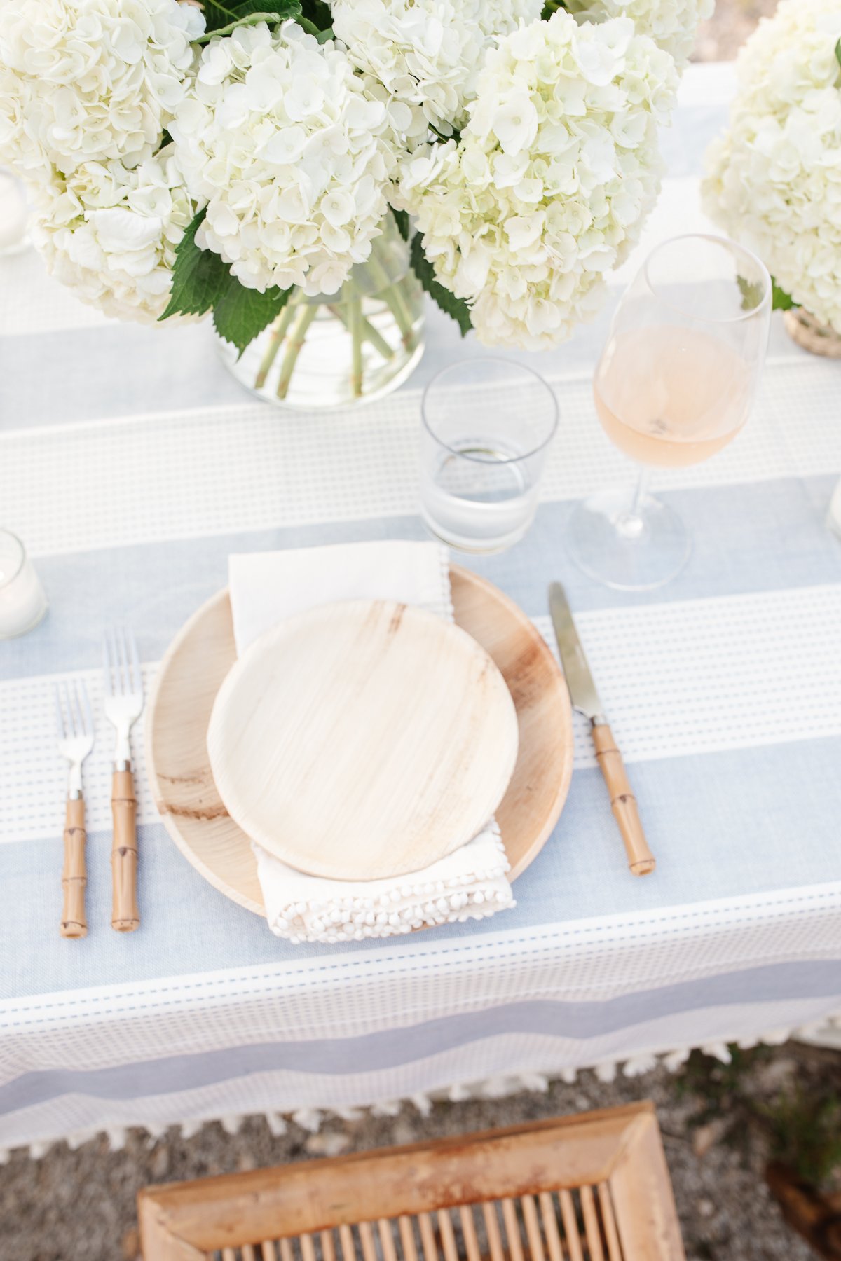 A table set up with bamboo dining chairs and water views for al fresco dining.