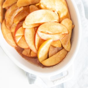 Baked apple slices in a white dish.
