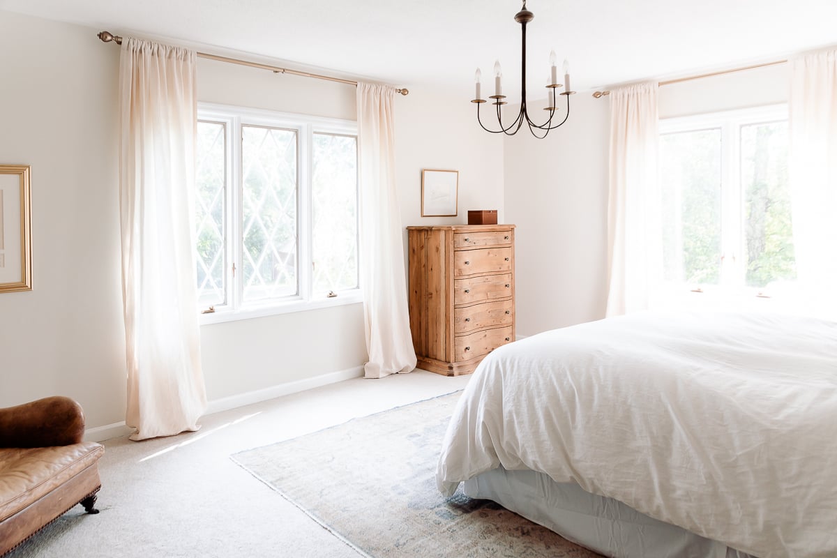 A bedroom with a vintage rug under a king size bed.