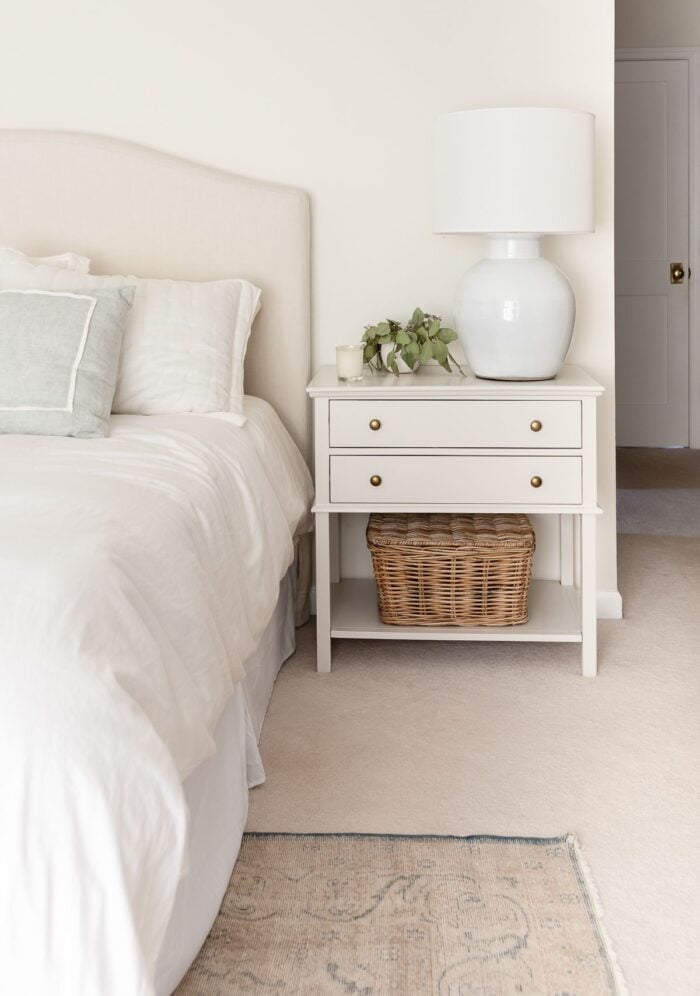 A nightstand in a cream bedroom, painted in Pale Oak Benjamin Moore paint color.
