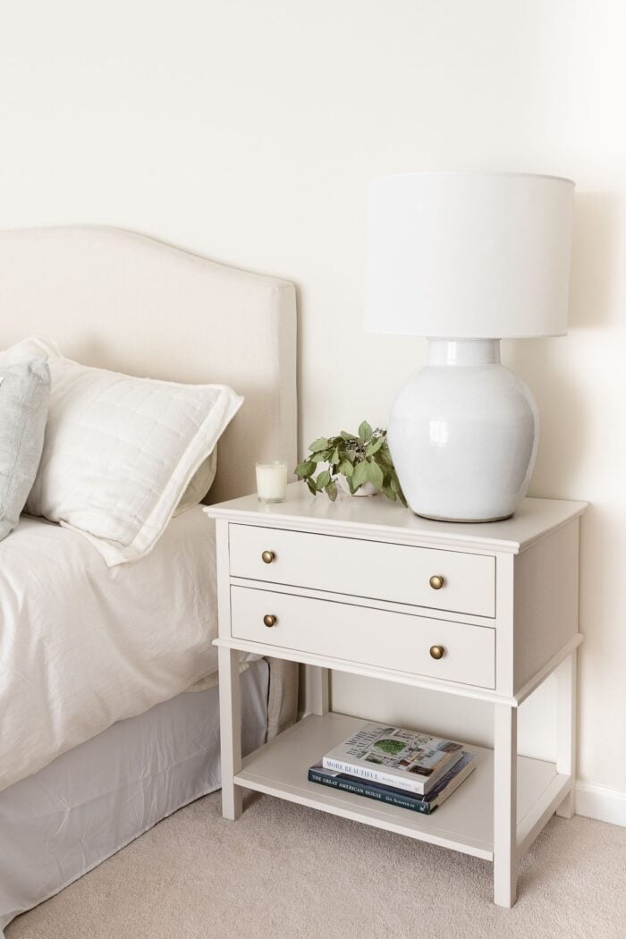 A nightstand in a cream bedroom, painted in Pale Oak Benjamin Moore paint color.