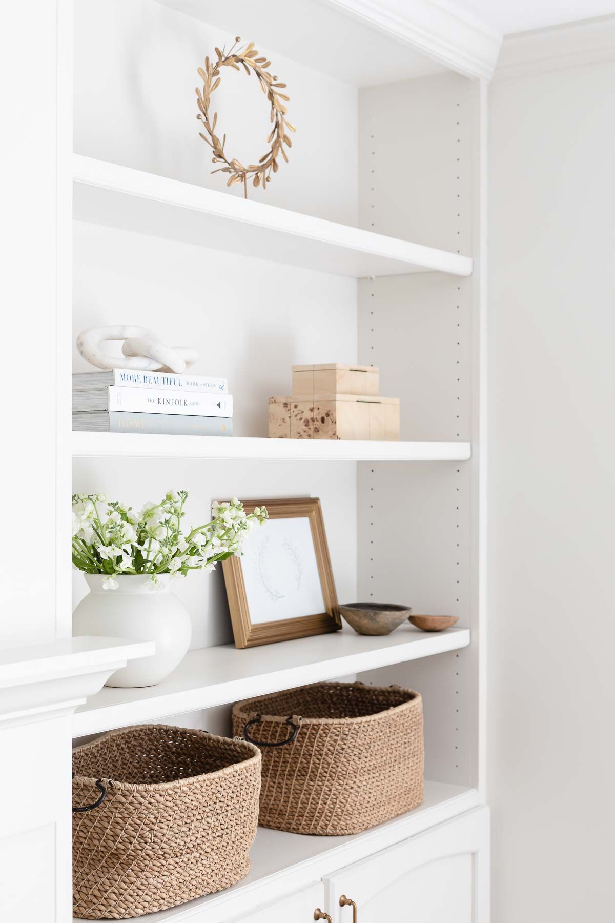 Built in bookshelves styled with neutral decor and home accessories.