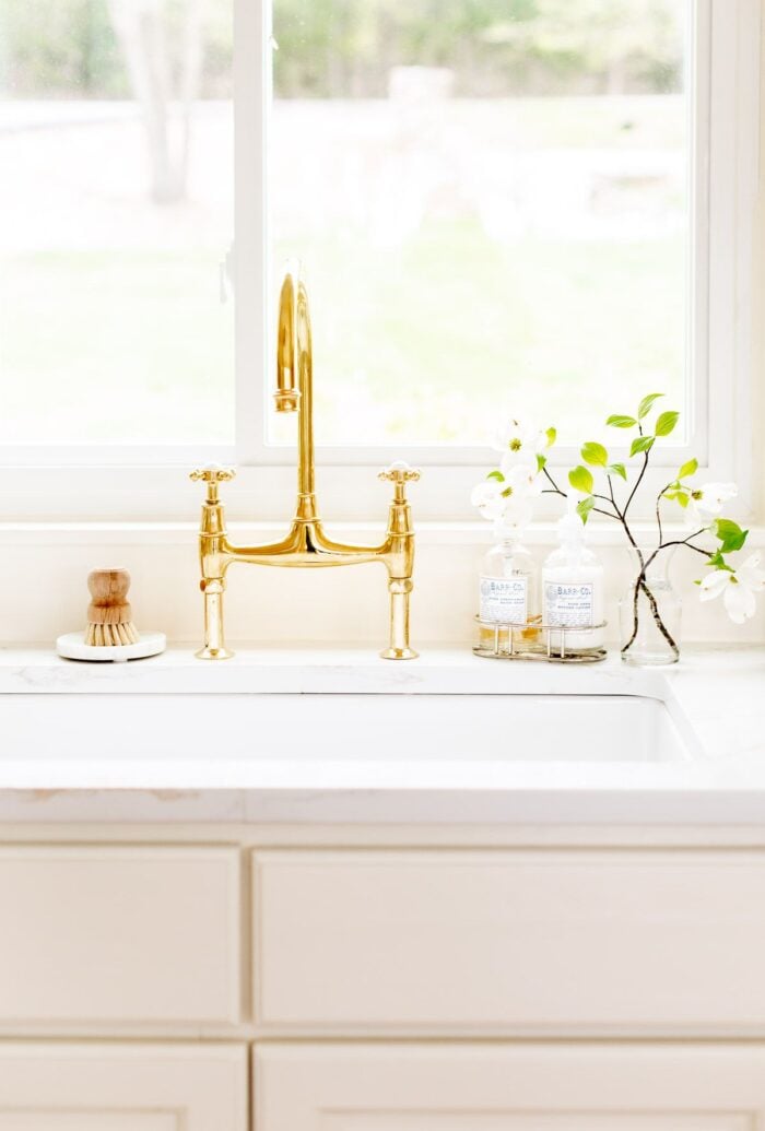 A white quartz countertop with an eased countertop edge, brass faucet on the sink.