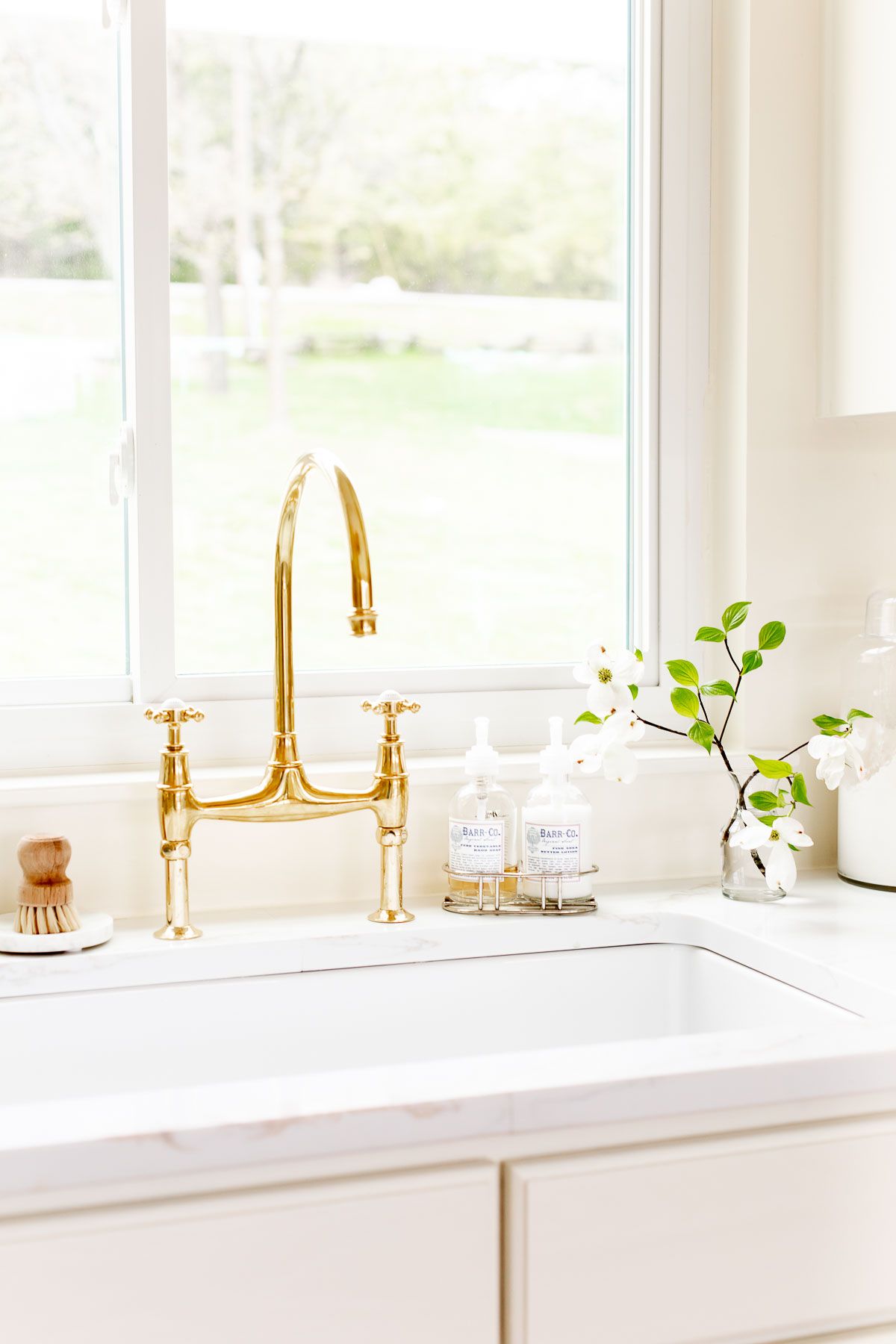 A white quartz countertop with an eased countertop edge, brass faucet on the sink.