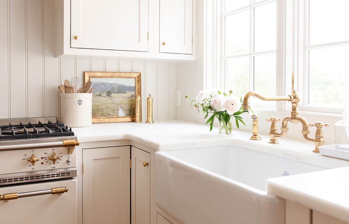 A cream-colored kitchen with a smooth-edged marble worktop.