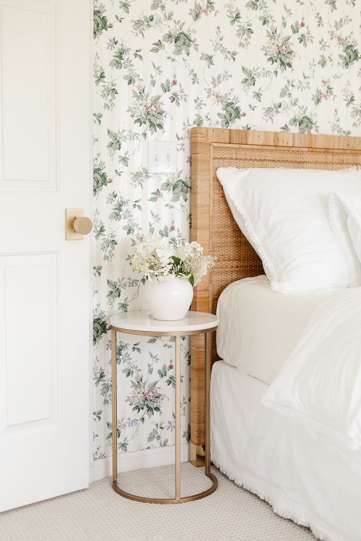 fresh cut limelight hydrangea blooms in a vase on a bedside table