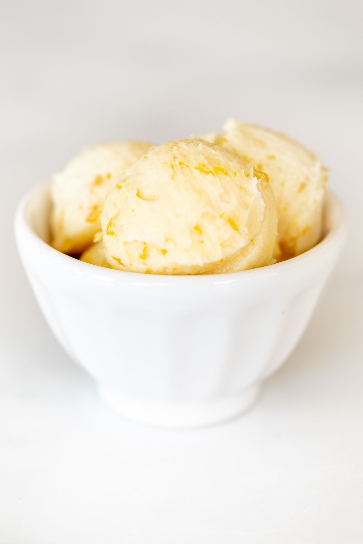 A white bowl filled with scoops of homemade orange butter.