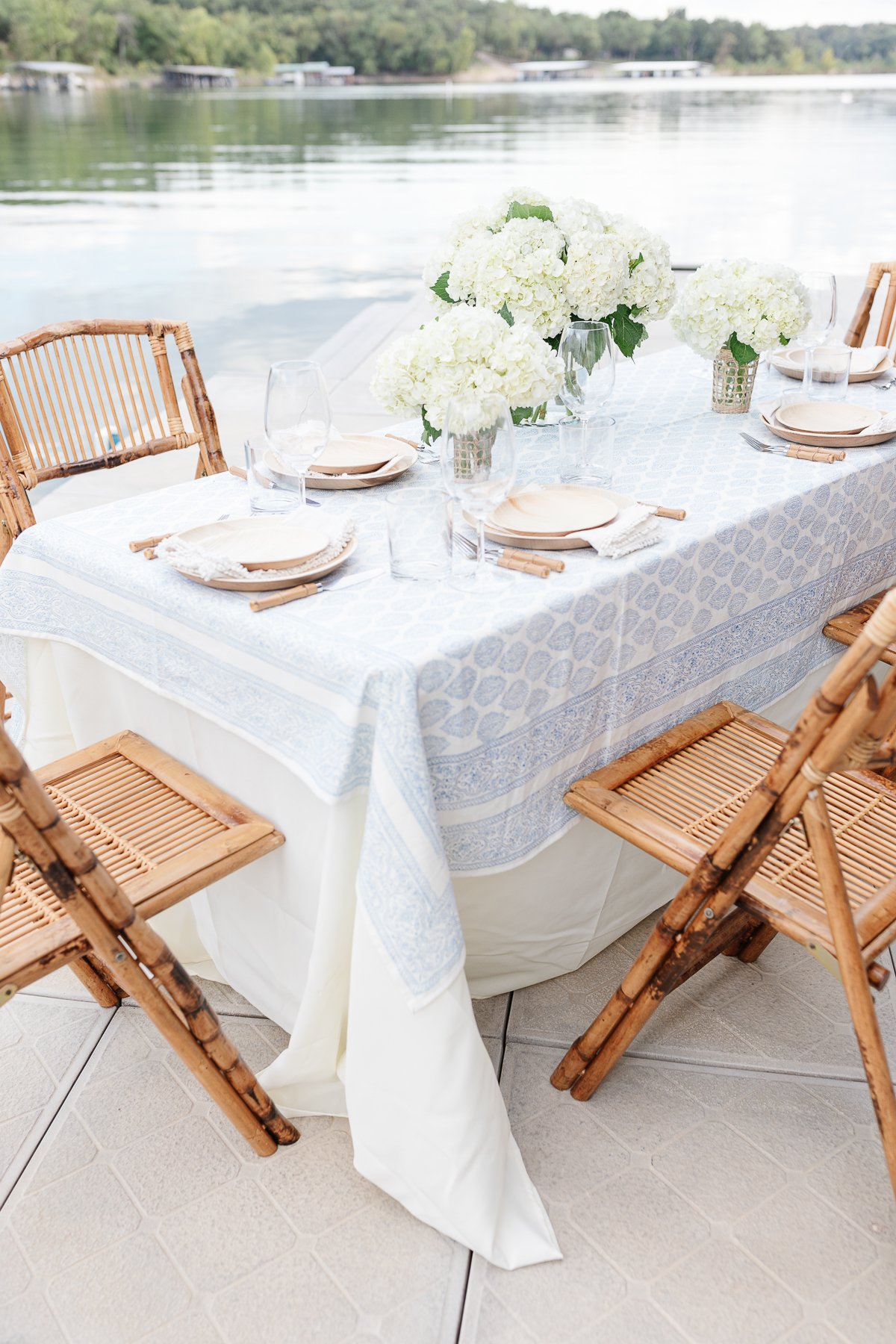 A table set up with bamboo dining chairs and water views for al fresco dining.