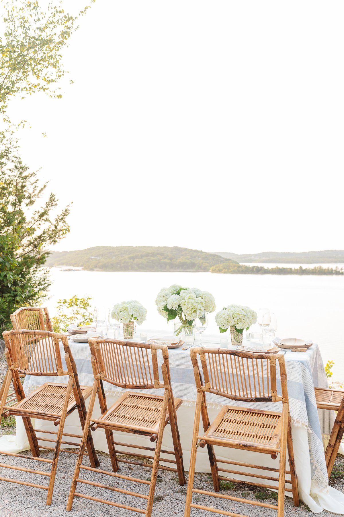A table set up with bamboo dining chairs and water views for al fresco dining.