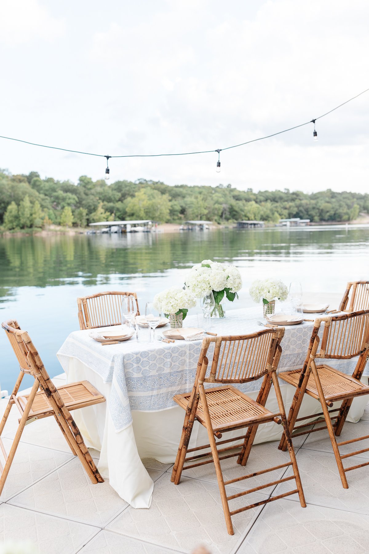 A table set up with bamboo dining chairs and water views for al fresco dining.