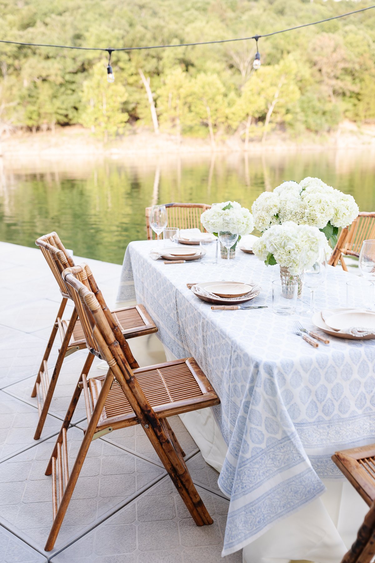 A table set up with bamboo dining chairs and water views for al fresco dining.