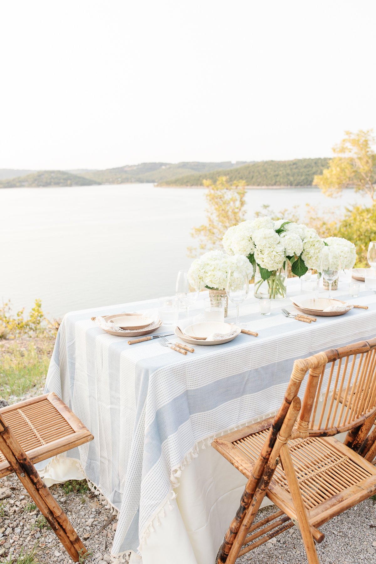 A table set up with bamboo dining chairs and water views for al fresco dining.