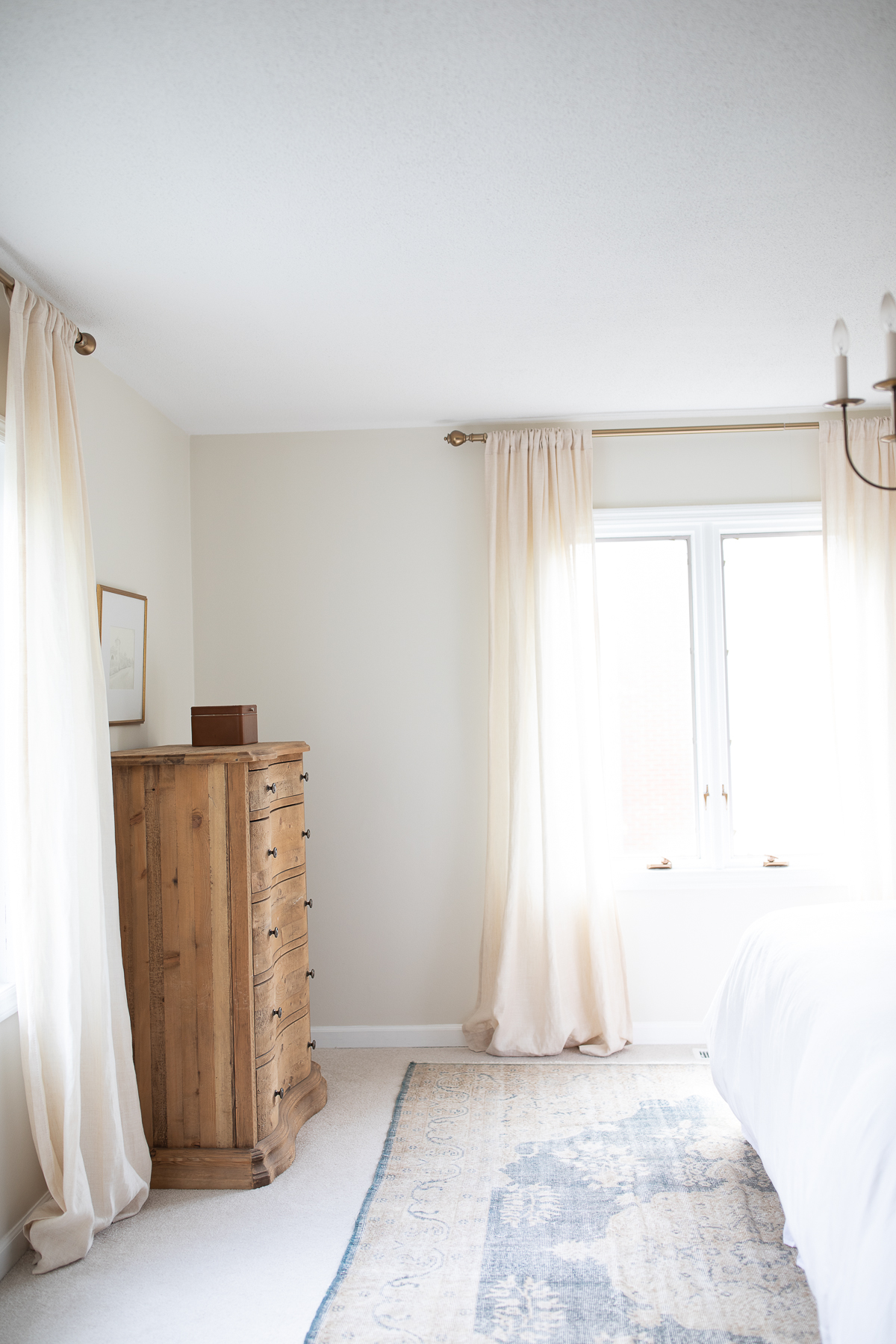 A bedroom with a dresser and a window, suitable for rug placement and measuring for a king bed.