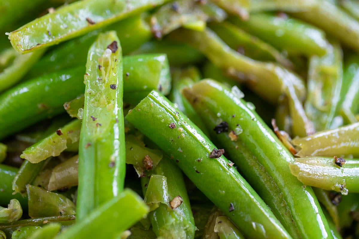 A close up of seasoned green beans on a plate.