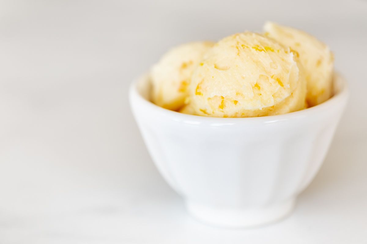 A white bowl filled with scoops of an orange butter recipe.