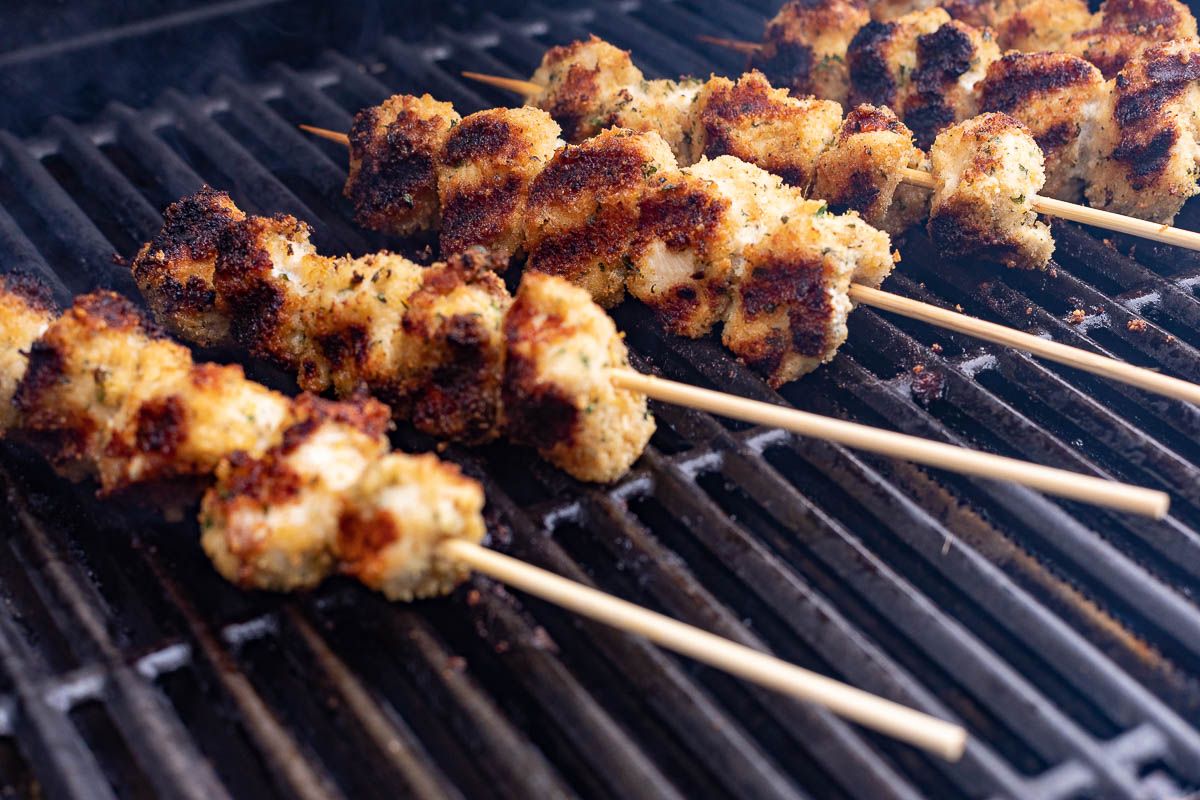 Spiedini skewers cooking on a grill.