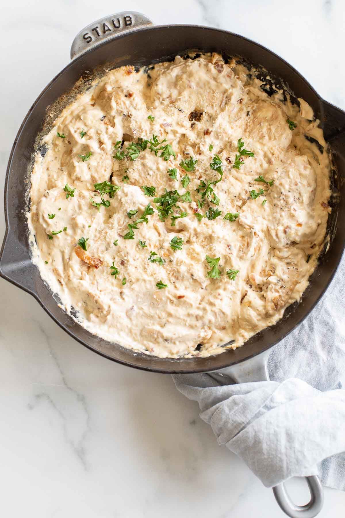 A cast iron skillet filled with cream cheese chicken