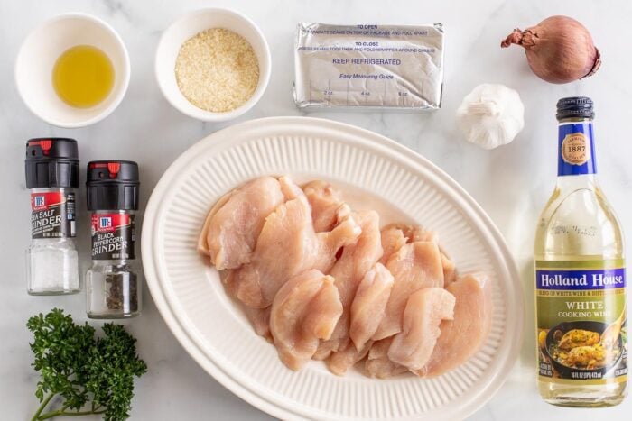 Ingredients for a cream cheese chicken recipe laid out on a marble countertop