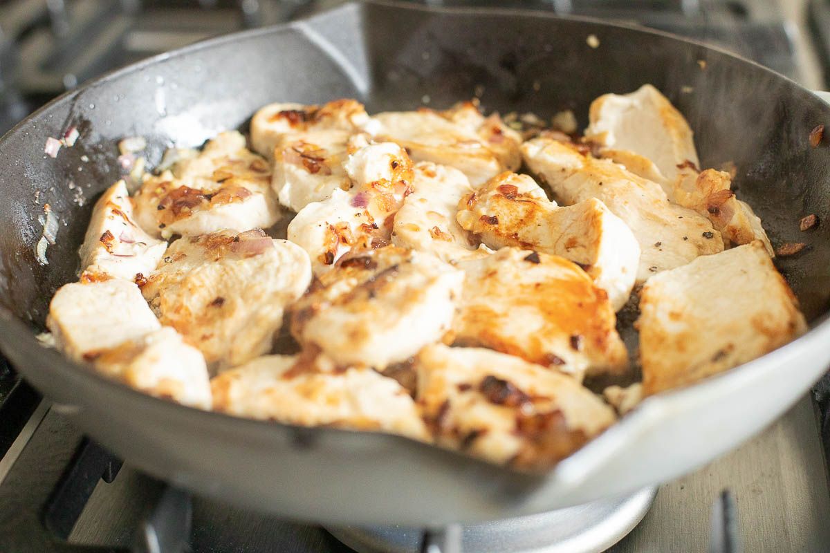 Chicken cutlets cooking in a cast iron skillet