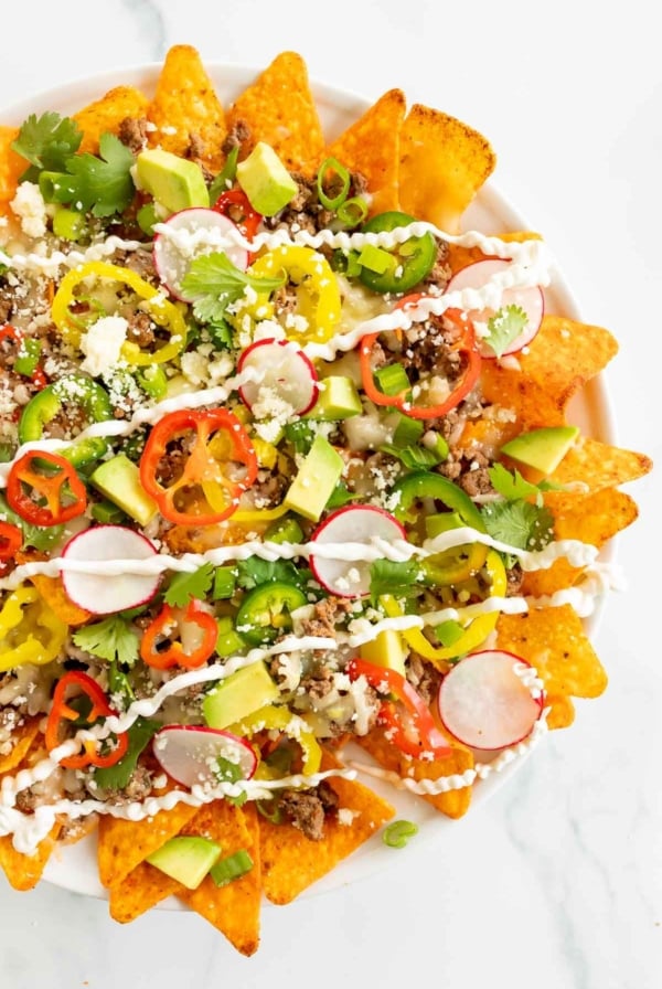 A plate full of a Doritos nachos recipe on a white surface.