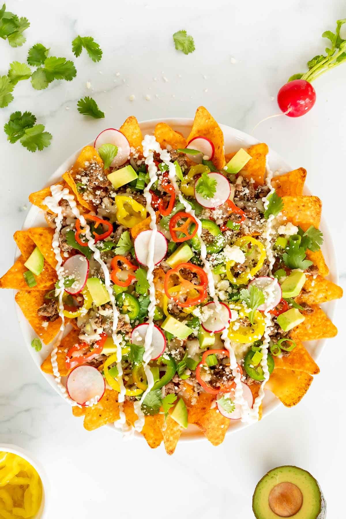 A plate full of a Doritos nachos recipe on a white surface.