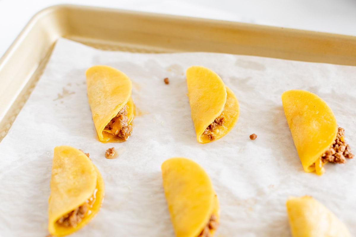 mini tacos on a parchment lined baking sheet.