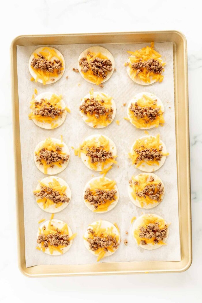 Mini tacos on a baking sheet with parchment paper.