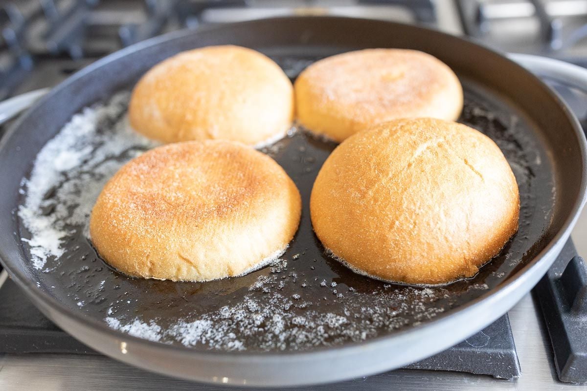 Toast burger buns in a cast iron skillet with melted butter