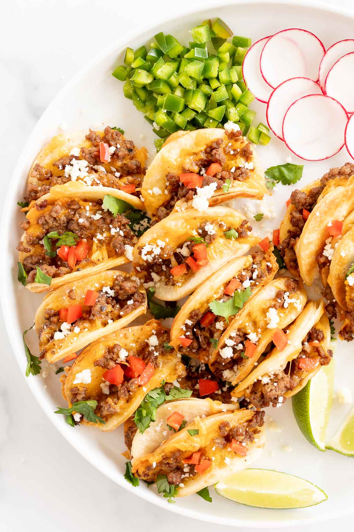 Beef mini tacos on a white platter.