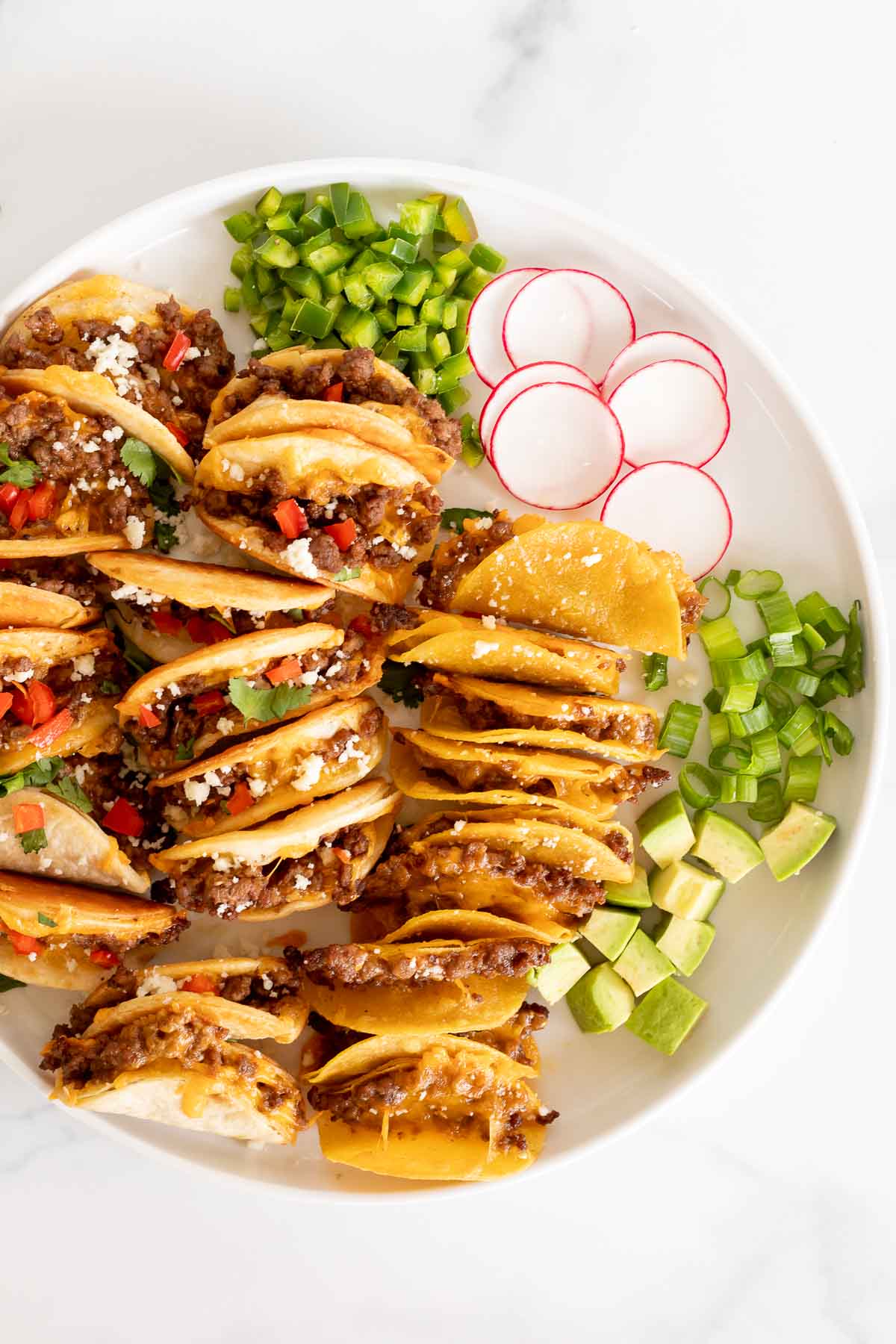 Beef mini tacos on a white platter. 