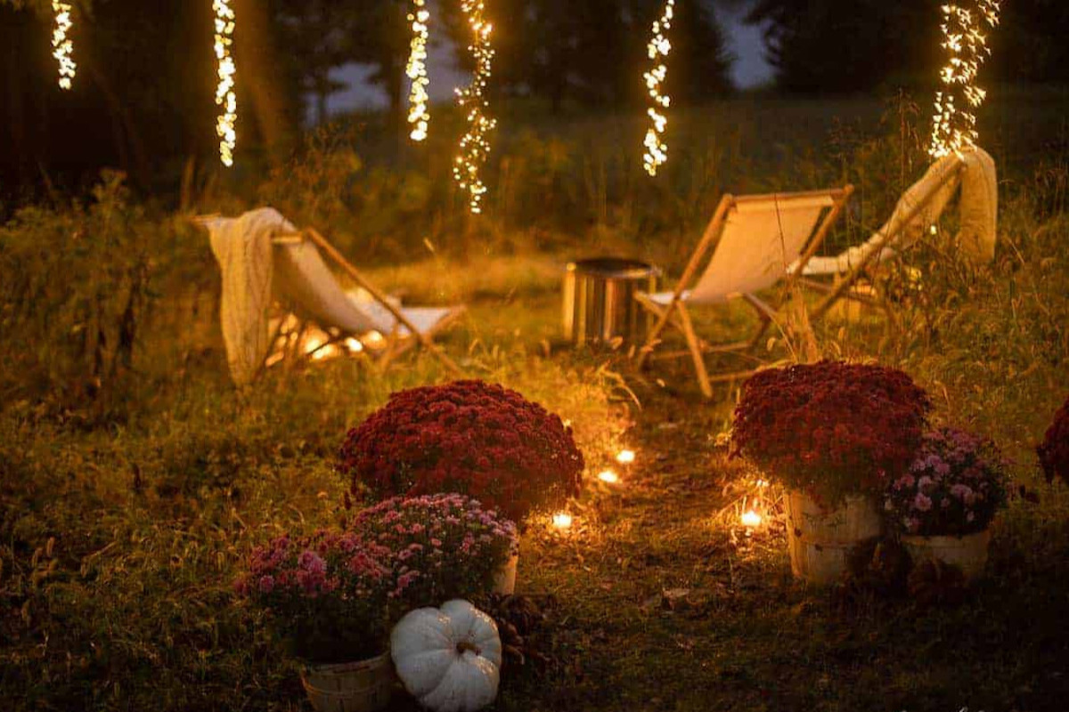 A fall fire pit decorated with fresh pumpkins and mums
