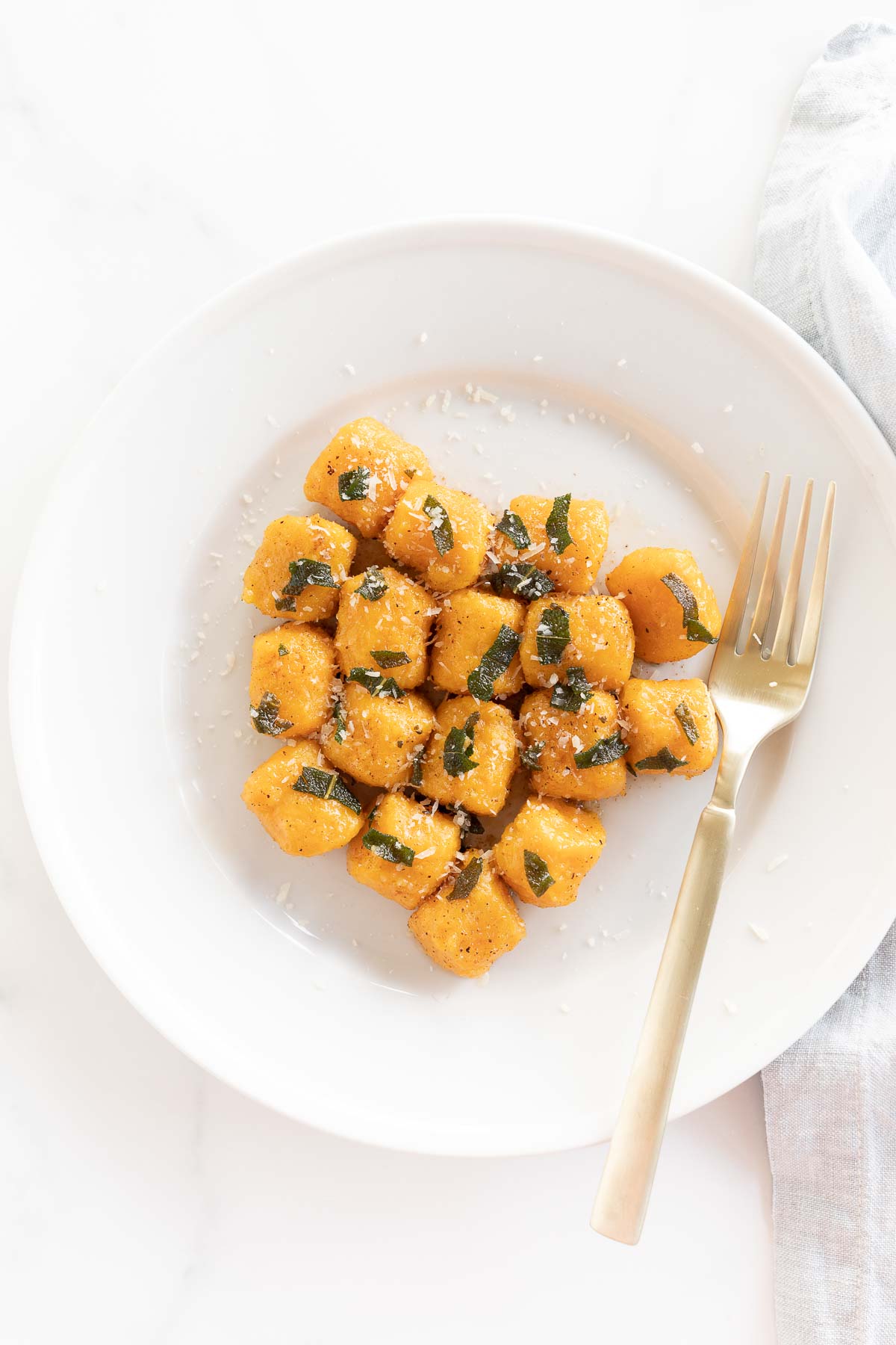 Sweet potato gnocchi on a white plate with a fork.
