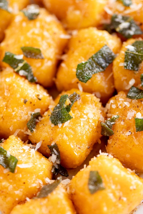 A delicious plate of sweet potato gnocchi topped with basil and parmesan cheese.