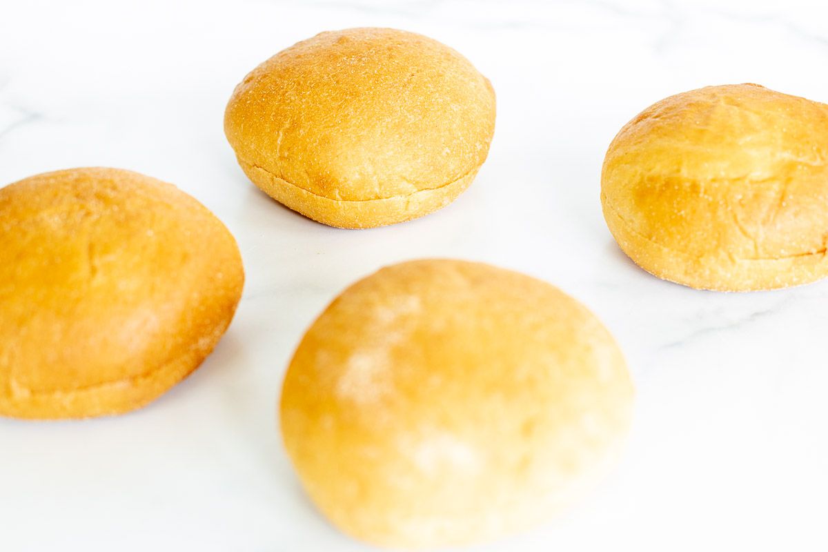 Hamburger buns laid out on a marble surface