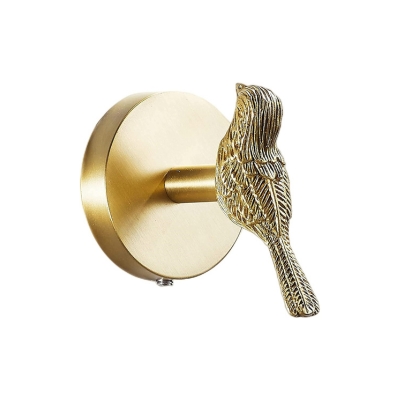 a brass robe hook in the shape of a bird, against a white background