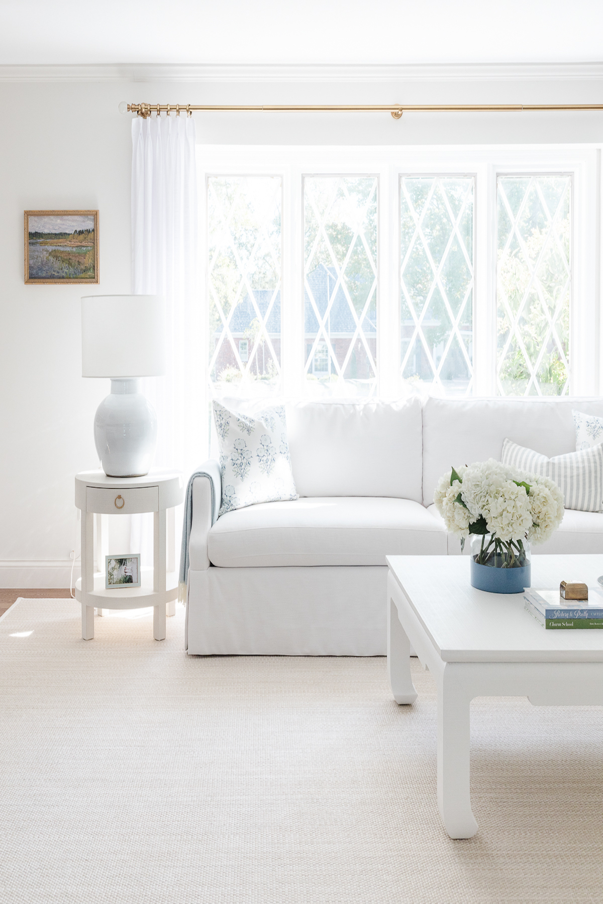 A white couch surrounded by neutral rugs in a living room.