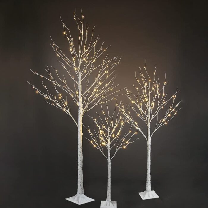 3 fairy light trees against a black background