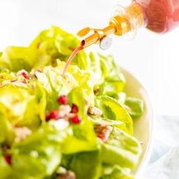 pomegranate vinaigrette pouring onto salad