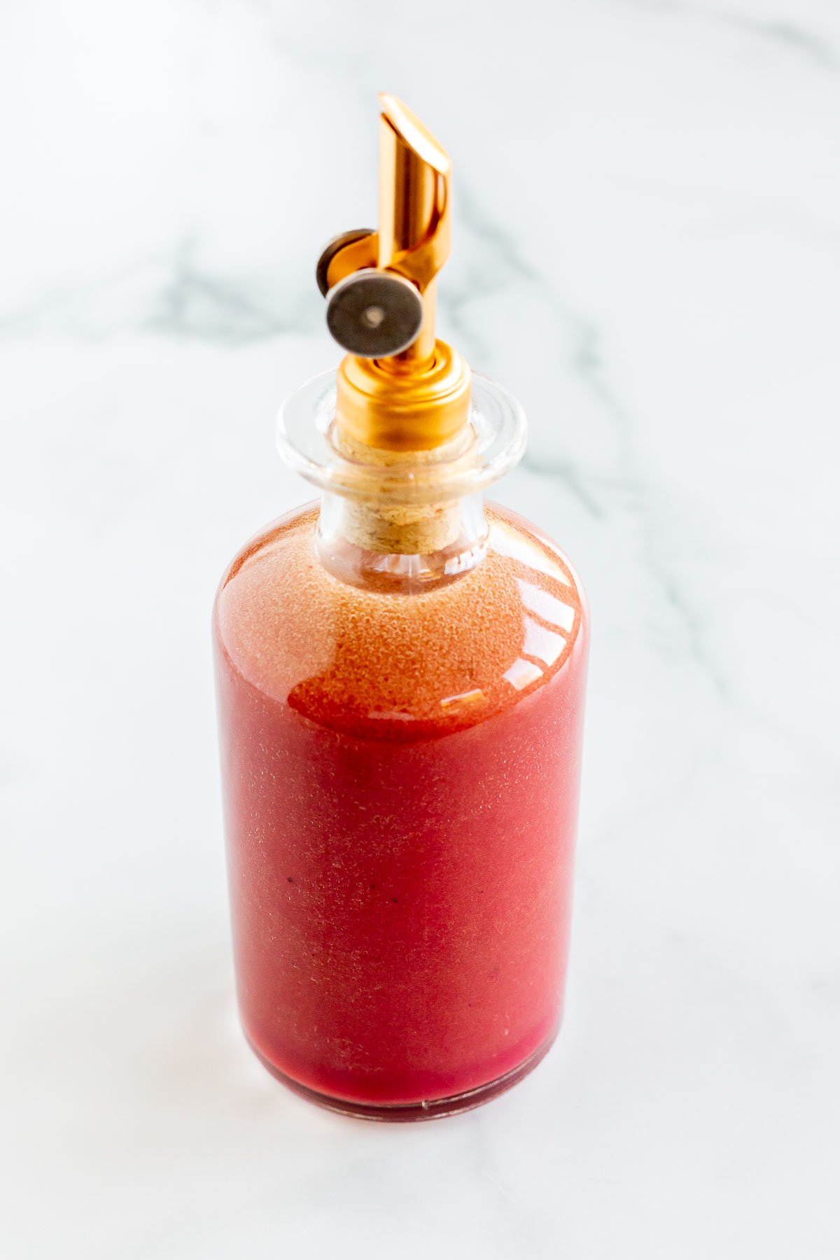 pomegranate dressing in a glass oil bottle