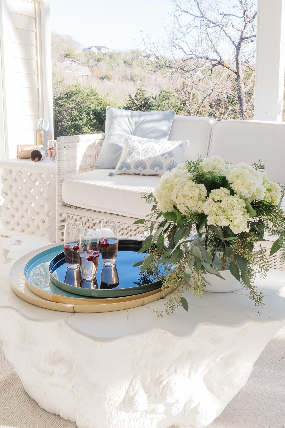 A white tree stump coffee table with a serving tray and flowers