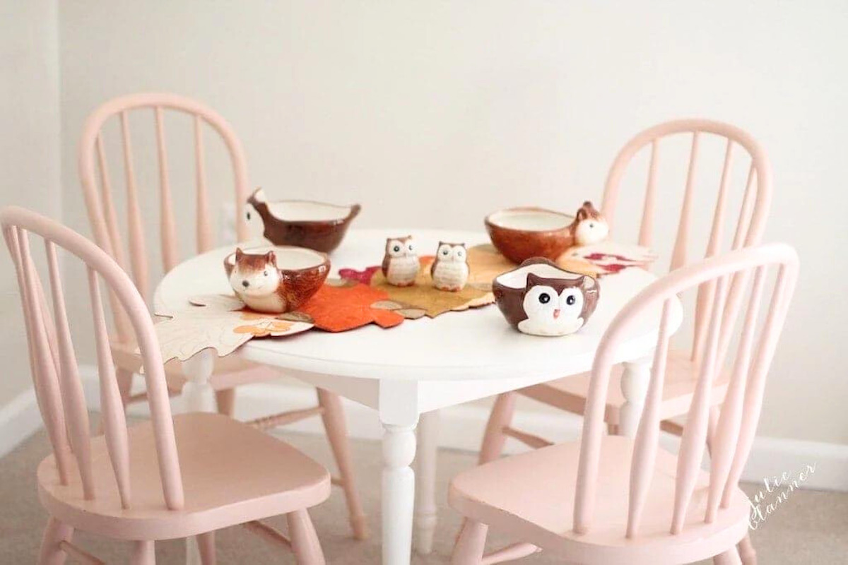 A pink table and chairs with adorable owl-themed Thanksgiving table decor.