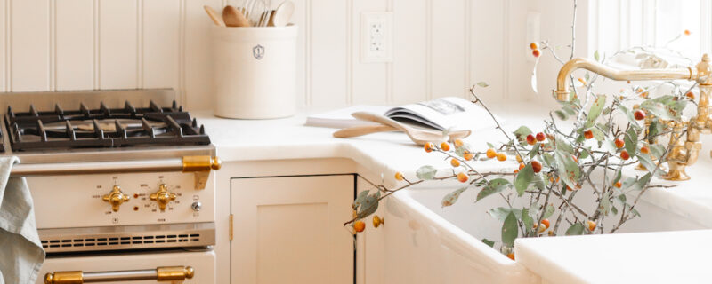 stove with cookbook and fall branches next to it